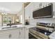 Well-lit kitchen featuring stainless steel appliances, white cabinetry, and marble countertops at 1713 Altavista Cir, Lakeland, FL 33810