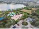 Aerial view of pool and clubhouse surrounded by lush landscaping and circle driveway at 1713 Altavista Cir, Lakeland, FL 33810