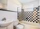 Bathroom features a shower/tub combo with black and white checkered tile and a matching sink at 6317 Georgia Ave, Lakeland, FL 33813