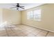 Bedroom featuring beige walls and tile floors with a ceiling fan and multiple windows at 6317 Georgia Ave, Lakeland, FL 33813