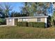 Charming single-story home with green hedges, enhancing the property's curb appeal with its natural elements and inviting facade at 6317 Georgia Ave, Lakeland, FL 33813