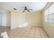 This open living room has tile floors, a ceiling fan, a closet, and natural light from the window at 6317 Georgia Ave, Lakeland, FL 33813