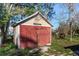 Detached storage shed with painted door and inscription adding a unique touch to the property's functionality and outdoor appeal at 6317 Georgia Ave, Lakeland, FL 33813