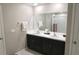 Bright bathroom with double sinks, dark wood cabinets, and a well-lit vanity mirror at 2206 Old Mining Rd, Lakeland, FL 33801