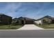 Inviting single-story home featuring a well-manicured lawn and a spacious two-car garage on a sunny day at 2206 Old Mining Rd, Lakeland, FL 33801