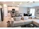 Open-concept living area with a modern sofa, kitchen island seating, and stainless steel appliances at 2206 Old Mining Rd, Lakeland, FL 33801
