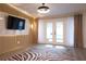 Inviting living area with wood-paneled wall, mounted TV, hardwood floors, and stylish curtains, leading to outdoor access at 1231 Sidcup Rd, Maitland, FL 32751