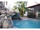 Resort-style pool with natural rock waterfall and tropical plants, offers a serene backyard retreat at 1231 Sidcup Rd, Maitland, FL 32751