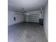 Spacious garage with concrete floor, a garage door opener, and a roll-up door at 145 Andreas St, Winter Haven, FL 33881