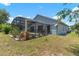 Charming backyard featuring a screened-in patio area and lush green lawn, perfect for outdoor enjoyment at 131 Vine Dr, Davenport, FL 33837