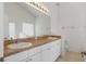 Bathroom featuring dual sinks, large mirror, and white cabinetry at 131 Vine Dr, Davenport, FL 33837