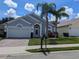 Charming single-story home featuring a two-car garage and mature landscaping, including palm trees at 131 Vine Dr, Davenport, FL 33837