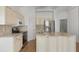 Kitchen with stainless steel appliances, a center island with sink and granite counters and cream cabinets at 131 Vine Dr, Davenport, FL 33837