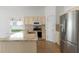 Kitchen with stainless steel appliances, a center island with sink and granite counters and cream cabinets at 131 Vine Dr, Davenport, FL 33837
