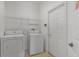 Functional laundry room with washer, dryer, and overhead shelving for storage at 131 Vine Dr, Davenport, FL 33837