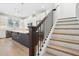 Staircase with wooden treads, view to open-concept kitchen with modern island at 2304 Depauw Ave, Orlando, FL 32804