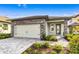 Charming home featuring stone accents, a two-car garage, and manicured landscaping at 7709 Somersworth Dr, Kissimmee, FL 34747