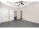 Open main bedroom featuring tray ceiling, ceiling fan, and en suite bathroom at 7709 Somersworth Dr, Kissimmee, FL 34747