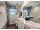 This bathroom boasts a double vanity, blue shower curtain, and decorative accents for a stylish feel at 1600 Ellesmere Ave, Haines City, FL 33844