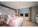This bedroom features a large bed, two windows, and a leaf accent wall for a unique style at 1600 Ellesmere Ave, Haines City, FL 33844