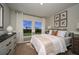 Bright bedroom featuring a large window with natural light and stylishly decorated walls with orange botanical art at 1600 Ellesmere Ave, Haines City, FL 33844