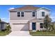 Charming two-story home with gray siding, a blue front door, well-manicured lawn, and an attached two-car garage at 1600 Ellesmere Ave, Haines City, FL 33844