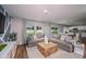 Spacious living room with a comfortable gray sectional, stylish decor, and wood flooring adjacent to the kitchen and dining area at 1600 Ellesmere Ave, Haines City, FL 33844