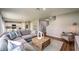 Spacious living room with a comfortable gray sectional, stylish decor, and wood flooring adjacent to the kitchen and dining area at 1600 Ellesmere Ave, Haines City, FL 33844