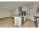 Modern kitchen with stainless steel appliances and island with a sink and seating area at 1604 Ellesmere Ave, Haines City, FL 33844