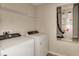 Well-equipped laundry room with modern washer and dryer, shelving, and utility connections at 1604 Ellesmere Ave, Haines City, FL 33844