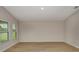 Bright room with three windows, neutral walls and baseboards, and light wood flooring at 1604 Ellesmere Ave, Haines City, FL 33844