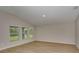 Neutral living room featuring three large windows, neutral walls, and light wood flooring at 1604 Ellesmere Ave, Haines City, FL 33844