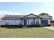 Charming single-story home featuring solar panels, a covered front porch, and a well-maintained lawn at 17 Trotters Cir, Kissimmee, FL 34743