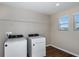 This bright laundry room has wood-look floors, shelving, and modern washer and dryer at 1901 Harrods Pl, Haines City, FL 33844