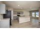 Bright, open kitchen features stainless steel appliances, a center island, and light wood floors at 1905 Harrods Pl, Haines City, FL 33844