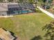 Large backyard with a screened pool, offering plenty of space for outdoor activities and potential for landscaping at 3931 Tano Dr, Ormond Beach, FL 32174