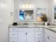 Bathroom with white cabinets, granite countertop, stylish decor and framed mirror at 3931 Tano Dr, Ormond Beach, FL 32174