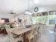 Dining room with table set for eight, large windows and modern light fixture at 3931 Tano Dr, Ormond Beach, FL 32174
