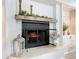 Living room fireplace with a wooden mantel, decorative greenery, and glass door at 3931 Tano Dr, Ormond Beach, FL 32174
