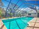 Sparkling pool is showcased within a screened enclosure and brick poolside at 3931 Tano Dr, Ormond Beach, FL 32174