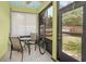 Screened-in porch with tiled floors, and neutral furnishings offers a relaxing outdoor space at 416 Country View Cir, Deland, FL 32720