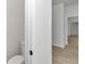 Bright bathroom with a toilet near the doorway and wood-look tile extending into the hallway at 7 Hill Prince Dr, Ocala, FL 34482