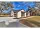 View of stucco home, showing garage and driveway at 7 Hill Prince Dr, Ocala, FL 34482