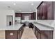 New kitchen featuring stainless steel appliances, granite countertops and dark wood cabinets plus a large island at 7 Hill Prince Dr, Ocala, FL 34482