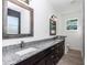 Bright bathroom featuring double granite vanity and framed mirrors at 7 Hill Prince Dr, Ocala, FL 34482