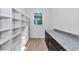Large walk-in pantry with custom shelving, granite countertop, and dark wood cabinets at 7 Hill Prince Dr, Ocala, FL 34482