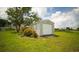 A detached single car garage featuring white siding and a white door, with a well maintained lawn at 10672 Sw 75Th Ter, Ocala, FL 34476