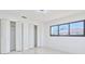 Clean bedroom featuring folding closet doors, a modern window, and smooth flooring at 2310 Laguna Dr, Indian Lake Estates, FL 33855