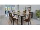 Bright dining room featuring a stylish table, seating for six, and a view to the living area at 2310 Laguna Dr, Indian Lake Estates, FL 33855