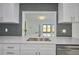 Modern kitchen with stainless steel sink, white cabinets, and ample counter space at 2310 Laguna Dr, Indian Lake Estates, FL 33855